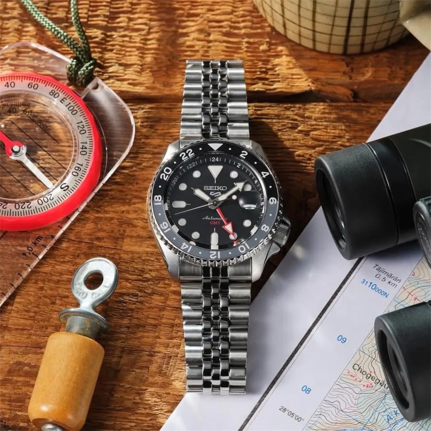 Seiko SSK001K1 Bruce Wayne GMT Seiko 5 Sports SSK001K1 «Bruce Wayne» — механический GMT с чёрно-серым безелем и красной GMT-стрелкой