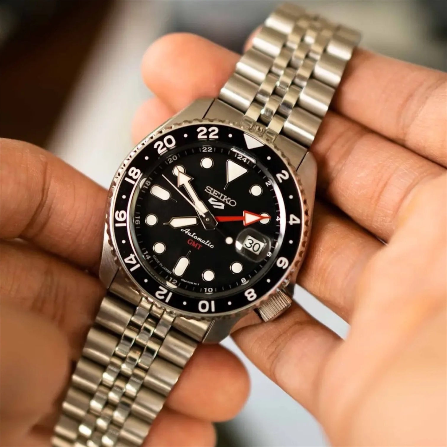 Seiko SSK001K1 Bruce Wayne GMT Seiko 5 Sports SSK001K1 «Bruce Wayne» — механический GMT с чёрно-серым безелем и красной GMT-стрелкой