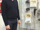 Михаил Михайлов у стенда с переданным фрагментом челюсти первобытной россомахи, Тюмень