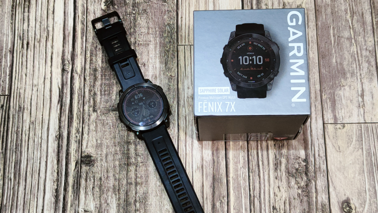 человек настраивает приложение на смартфоне рядом с часами garmin fenix человек настраивает приложение на смартфоне рядом с часами garmin fenix