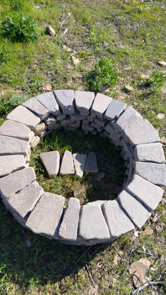 На травке уложен очаг из камня