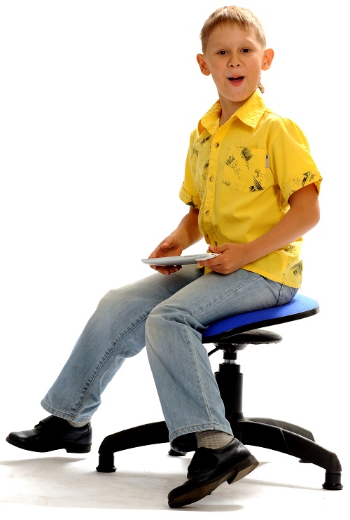Мальчик в желтой рубашке сидит на танцующем стуле Фото