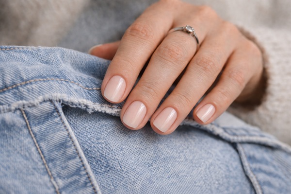 фотография руки с нюдовым/молочным маникюром в lifestyle-контексте одежды