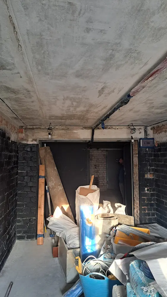 garazh-do-remonta-obshchiy-vid-minsk Общий вид гаража до начала ремонта — строительные материалы, ворота, бетонный потолок.