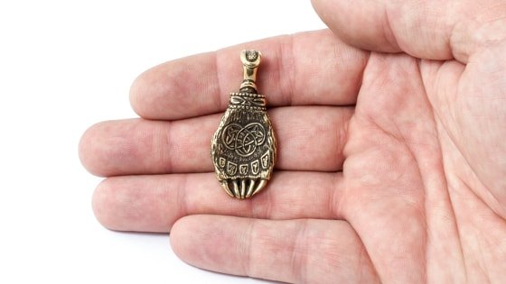 Фотография бронзовой лапы Велеса на руке.