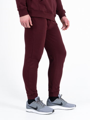 Спортивные штаны цвета красного вина с манжетами, без лампасов. Плотный футер