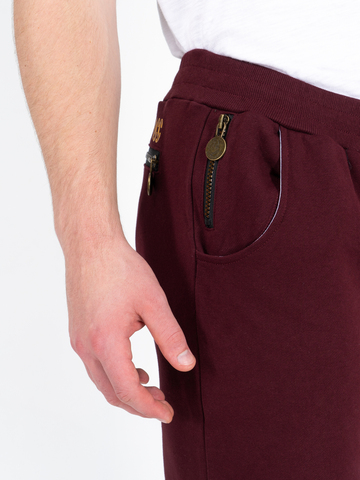 Спортивные штаны цвета красного вина с манжетами, без лампасов. Плотный футер
