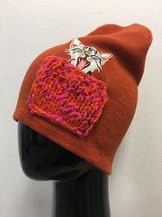 Зимняя шапка ANRU с котиком в ярко-розовом кармашке на терракотовым фоне - это стильный и теплый головной убор, который станет отличным дополнением к вашему гардеробу.