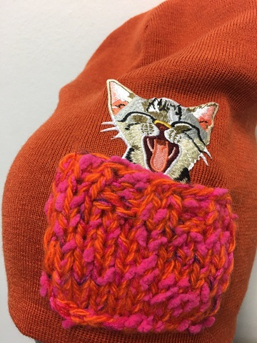 Зимняя шапка ANRU с котиком в ярко-розовом кармашке на терракотовым фоне - это стильный и теплый головной убор, который станет отличным дополнением к вашему гардеробу.