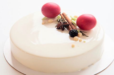 Безглютеновый муссовый торт украшен ягодами и белой глазурью