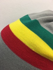 Растаманский флаг (зелено-желто-красный) на сером фоне.