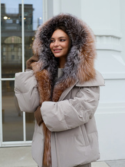 Бежевый пуховик с оторочкой из меха енота