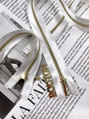 Молния на белой атласной тесьме золотистая