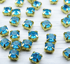 ЗЦ004НН66 Хрустальные стразы в цапах (шатоны), цвет: голубой (золото), размер: 6х6 мм, 24-25 шт.