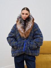 Синий текстильный пуховик в клетку с мехом енота