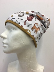 Удлиненная шапочка из хлопкового и вискозного трикотажа с разноцветными котиками на белом фоне.