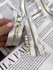 Молния на белой атласной тесьме золотистая