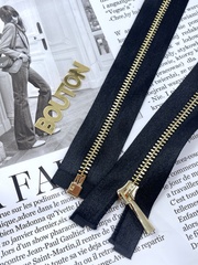 Молния на черной атласной тесьме золотистая