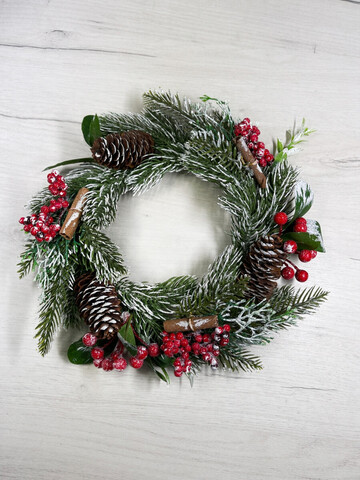 Венок еловый 25см ChristmasDeLuxe с красными ягодами и шишками заснеженный