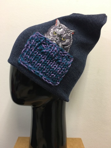 Зимняя двойная удлиненная (высота около 28 см) шапочка, сбоку декорирована нашивкой в виде котика, который уютно устроился в связанном вручную кармашке. Цвет шапочки - джинсовый меланж.