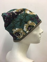 Демисезонная шапочка двойная с желтыми и фиолетовыми цветами и листиками на зеленом фоне.