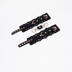 Черные кожаные наручники с узорами и золотистой фурнитурой