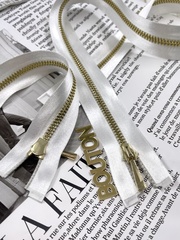 Молния на белой атласной тесьме золотистая