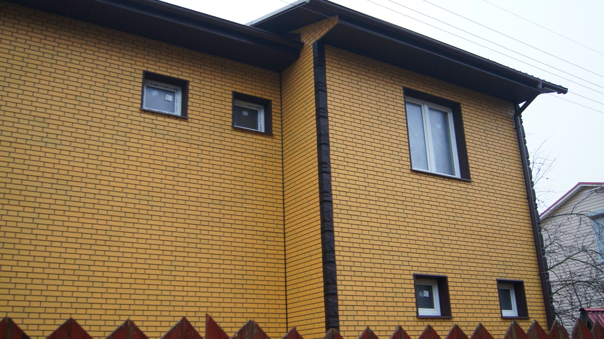 Фото домов обшитых фасадными панелями под кирпич желтый
