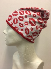 Удлиненная шапочка из хлопкового и вискозного трикотажа с отпечатками губ с красной помадой на белом фоне.