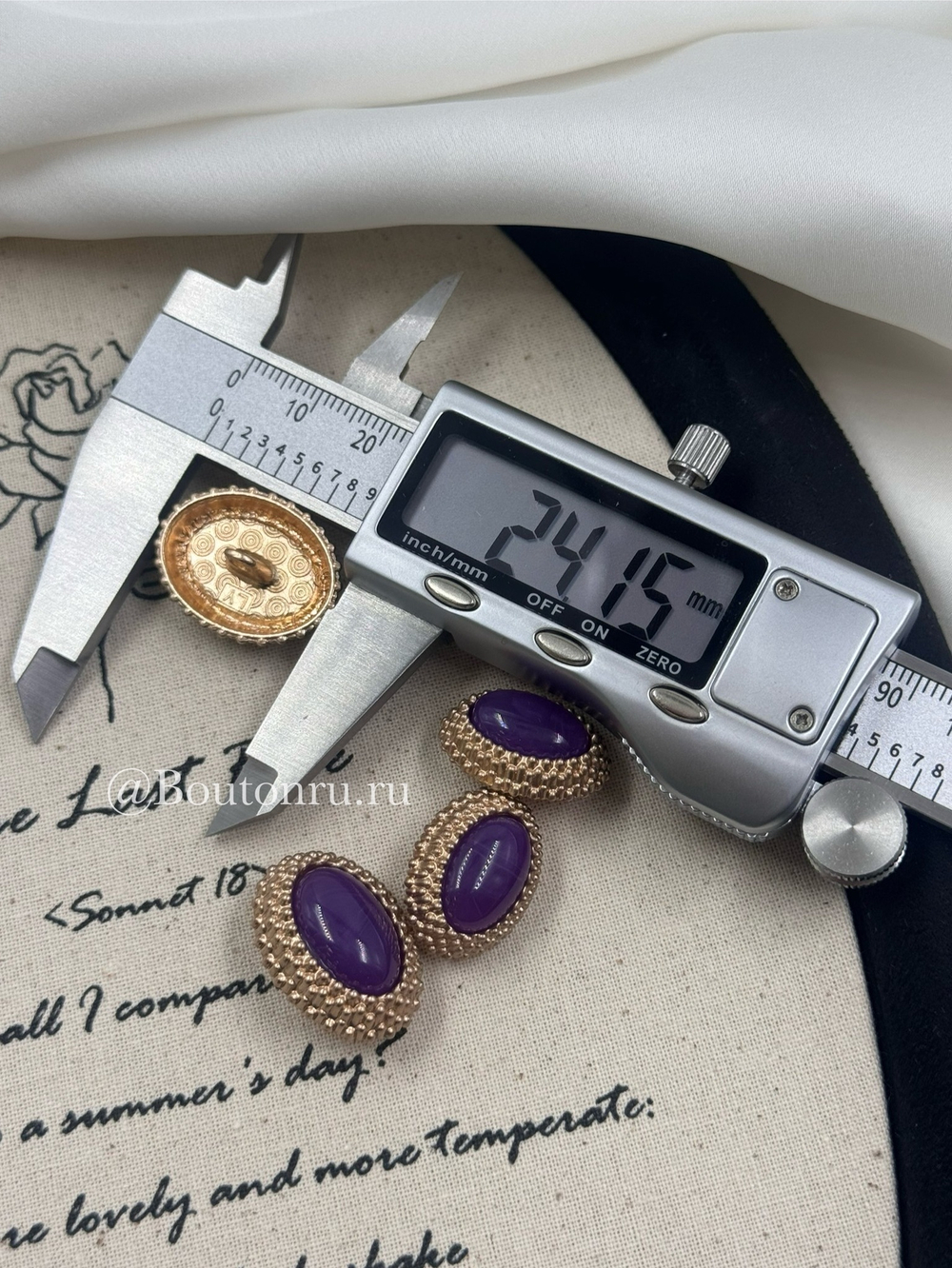 Пуговицы овальной формы золотистые с фиолетовым камнем