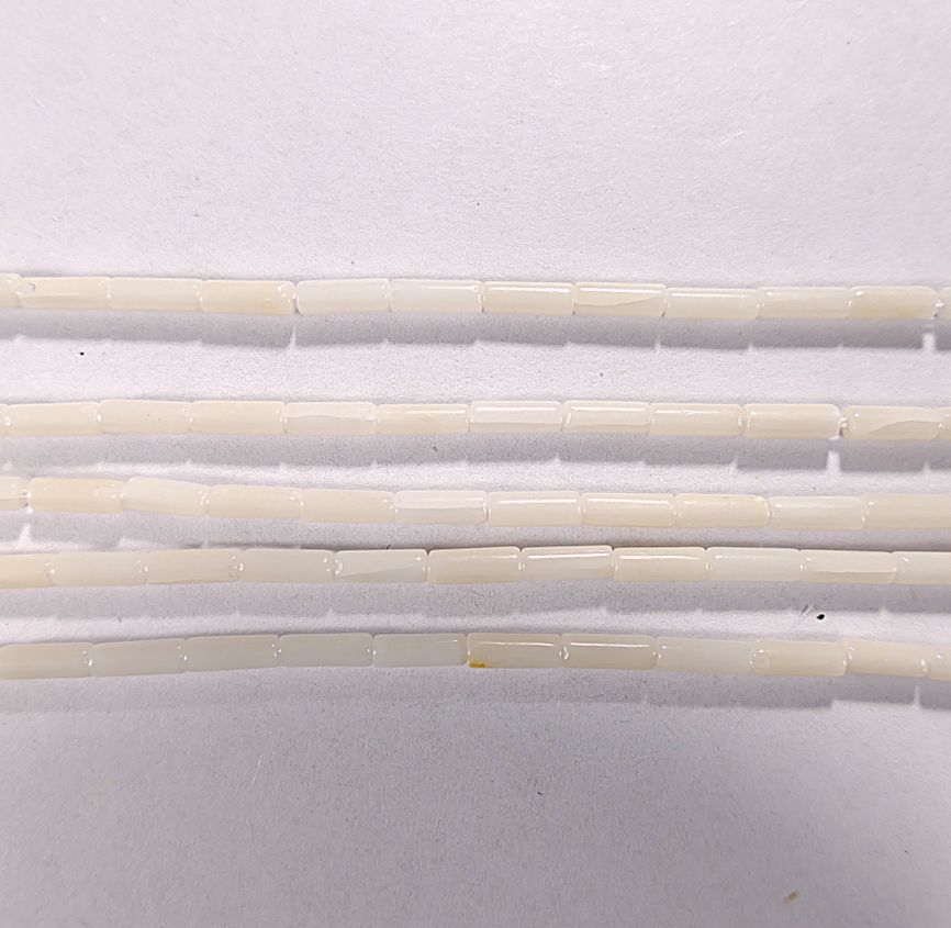 Нить бусин из коралла белого, облагороженного, фигурные, 2x6 мм (цилиндр, гладкая)