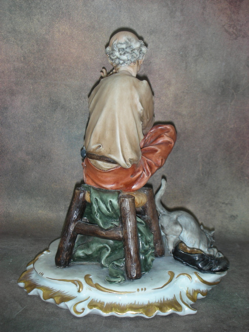 Статуэтка. Фарфор. Мужчина, зашивающий носок. Capodimonte. Италия