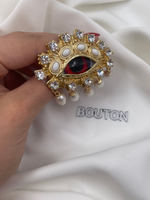 Брошь Скиапар. золотистая в форме красного глаза с жемчугом и стразами