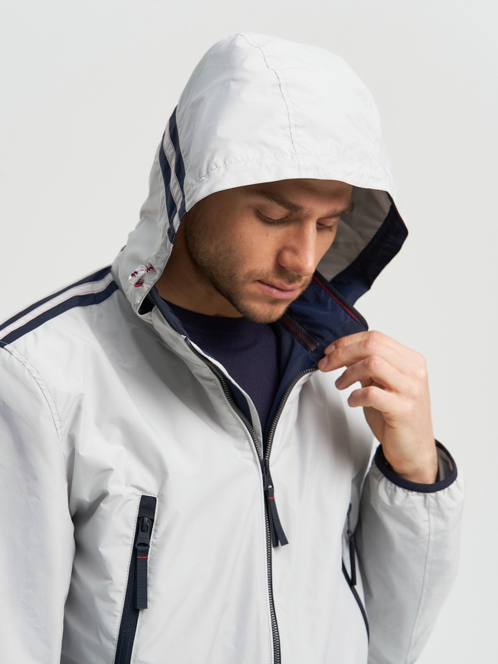 Мужская спортивная ветровка с капюшоном на резинке серого цвета.