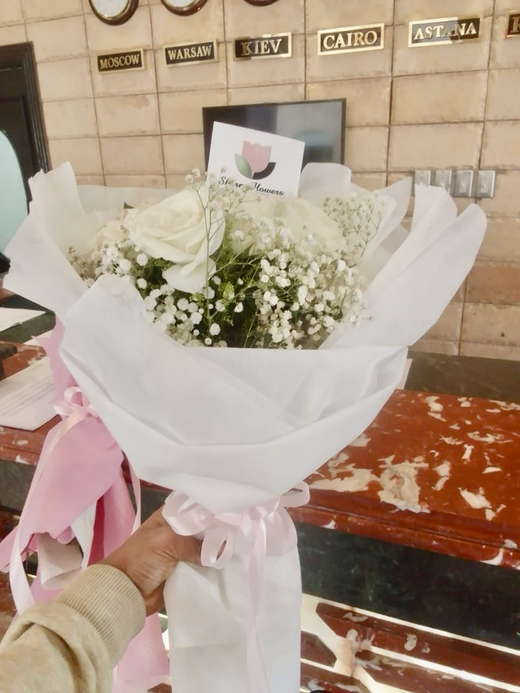 7 белых роз в дизайнерской упаковке