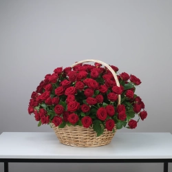 150 красных роз в плетеной корзине.