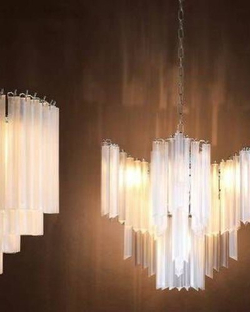 Изысканная каскадная люстра с вытянутыми стеклянными элементами и декоративной потолочной розеткой.