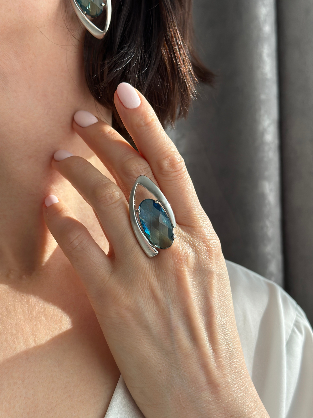 Кольцо зелено-голубой овальный кристалл в треугольной рамке в оттенке матовое серебро.