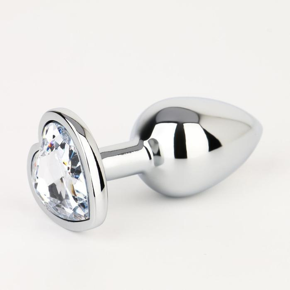 Серебристая анальная пробка с прозрачным кристаллом в форме сердца - 7 см.