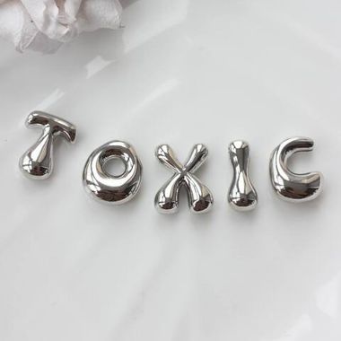 Слово из букв TOXIC в серебре