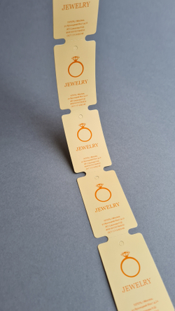 Печать оранжевым на бежевых бирках.