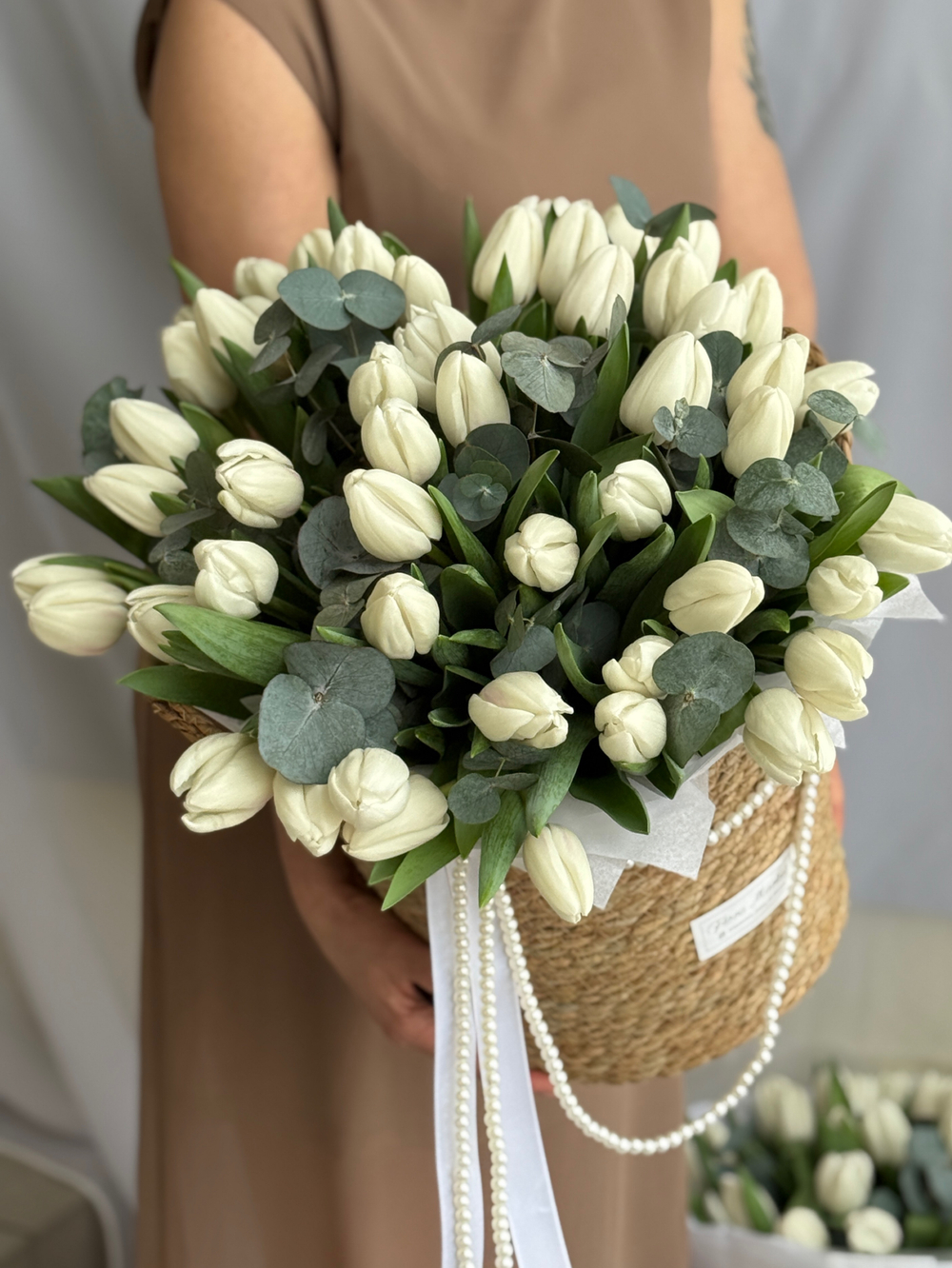 Охапка белых тюльпанов и благородный эвкалипт в стильной корзине от Флора Маркет