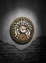 Необычные часы WOODandROOT «Башня Волшебника» с двойным циферблатом и ручной отделкой, освещённые диагональным светом на бетонной стене.