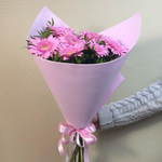 Нежный розовый букет из мини Гербер в упаковке с зеленью