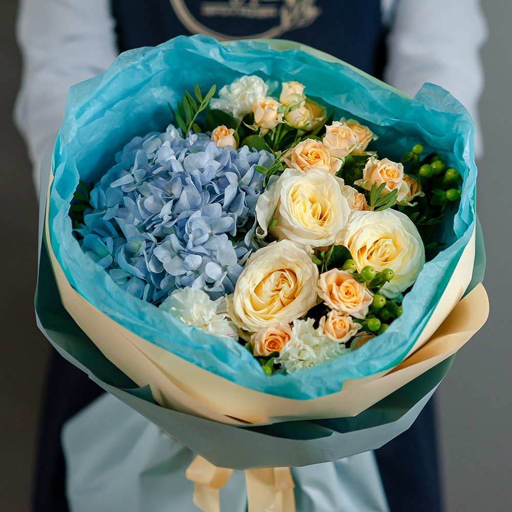 Пионовидные розы с голубой гортензией в стильном оформлении