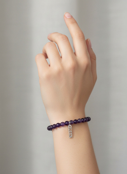 Фото браслета из натурального камня аметист с подвеской QUEEN из серебра на руке модели