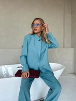 Костюм брючный в бирюзовом цвете с брошью-цветком