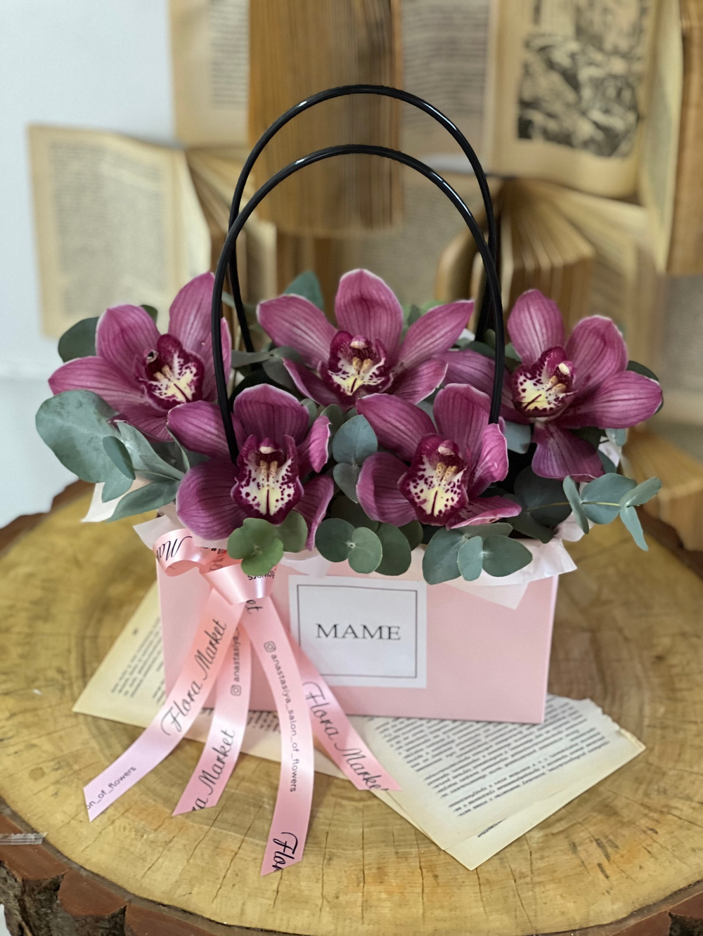 Композиция из орхидеи цимбидиум и эвкалипта в элегантном оформлении