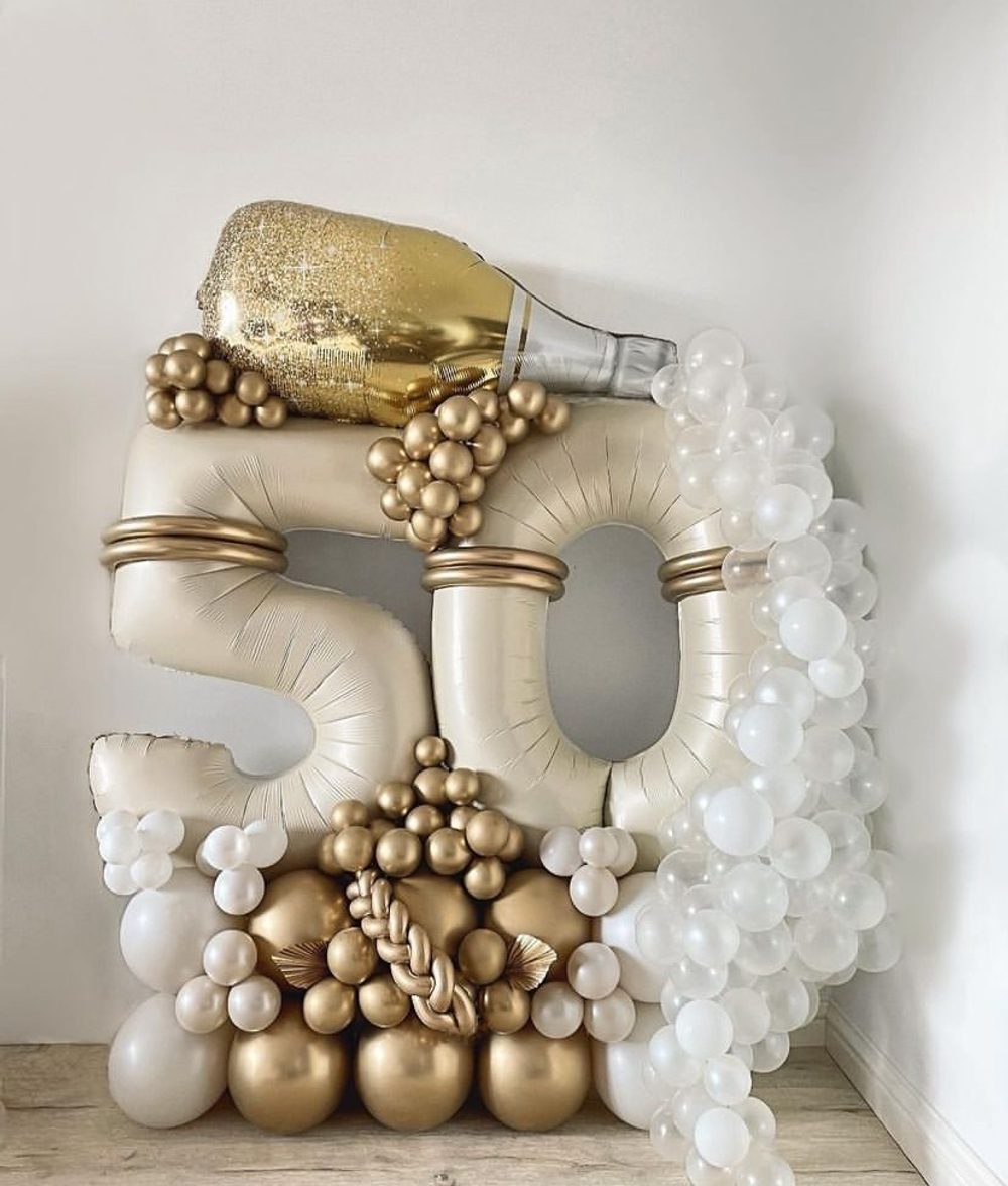 Бутылка шампанского на стойке с шарами