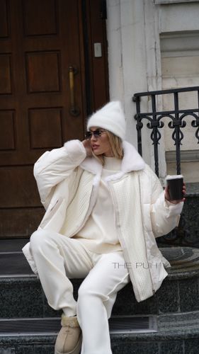 Белый пуховик с вязаными вставками и отделкой из меха